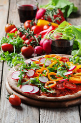 Vegan pizza with radish, tomato and paprika