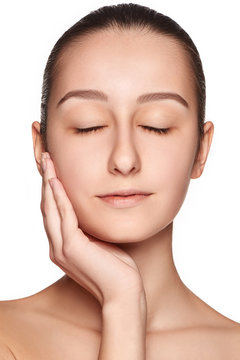 Portrait of beautiful girl stroking her face with healthy skin 
