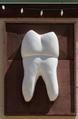 Large wooden tooth sign outside dentist
