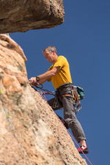 Senior man at top of rock climb in Colorado