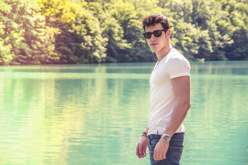 Attractive young man on lake in sunny day