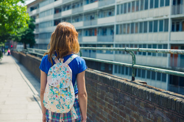 Obraz premium Young woman looking at apartment block