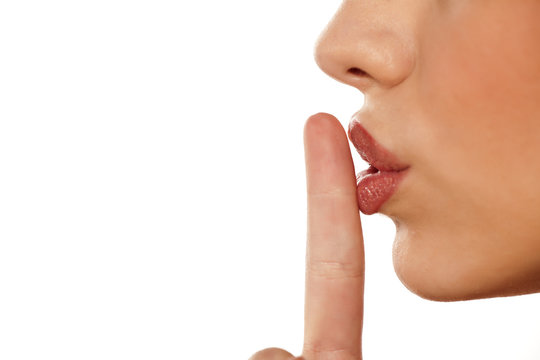 finger on her lips. silence gesture