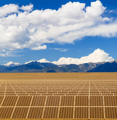Solar panels in sun under mountains