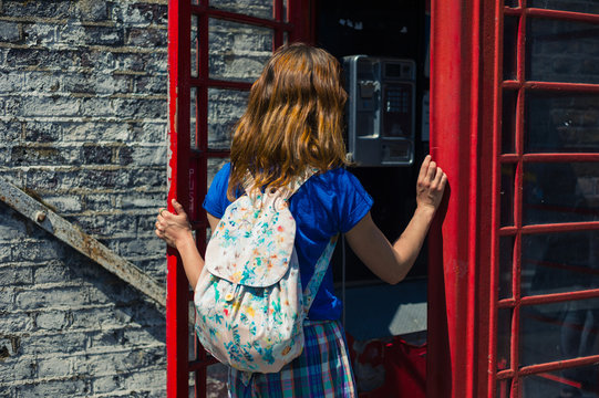 Young woman entering a phone booth
