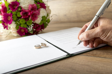 Man signing a marriage register - obrazy, fototapety, plakaty