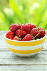 Strawberries berry in bowl on grey wooden background