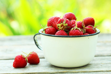 Strawberries berry in cup on grey wooden background