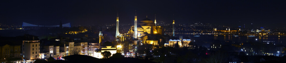 Fototapeta na wymiar Wide angle panorama of Istanbul old city district nightlight illumination Large panorama including most famous attractions Sophia Blue Mosque water Bosporus and Asian side town on background