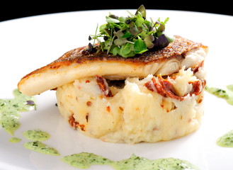 Tasty healthy fish fillet with potato puree with dried tomatoes and wild garlic sauce
