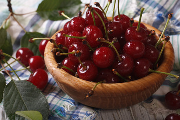 Ripe red cherry in a wooden bowl closeup. horizontal