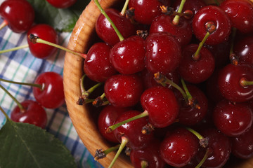 Ripe cherries in a wooden bowl macro. horizontal top view
