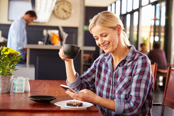 Woman using smart phone at a coffee shop