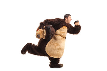 Horrified man in a bear costume running