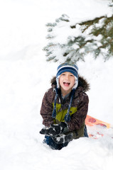 Fototapeta na wymiar young boy outdoors in winter clothing playing in the snow