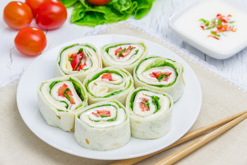 Tortilla roll with soft cheese, chicken ham, and vegetables
