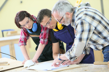 Young people in carpentry course with teacher - obrazy, fototapety, plakaty