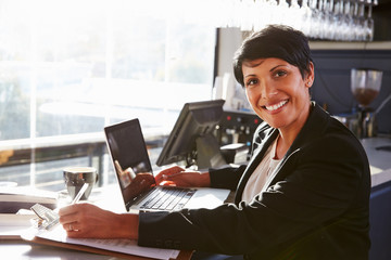 Female restaurant manager working at counter