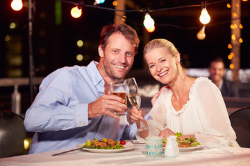 Couple eating dinner at rooftop restuarant