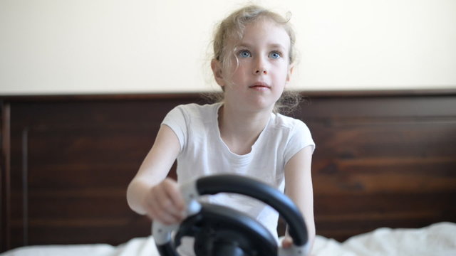 Little girl playing game with steering wheel.