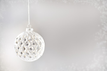 Frosty Christmas Border & Glass Ornament on silver background with copy space. 
