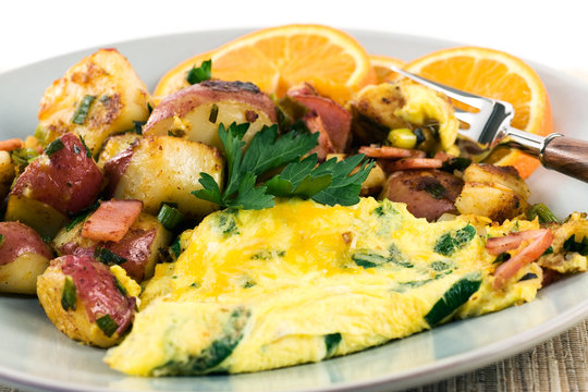 Hearty Breakfast, egg omelet with grilled potatoes, ham and seasoned with parsley and spices. 