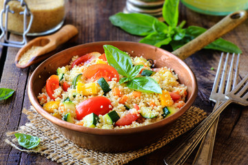 Delicious homemade vegetarian couscous with tomatoes, carrots, zucchini, yellow bell pepper and...