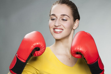 sexy fighting young woman showing her hands in boxing gloves to challenge life time