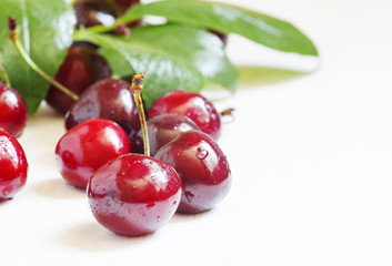 Ripe black cherry on a white wooden background, selective focus