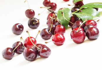 Ripe black cherry on a white wooden background, selective focus