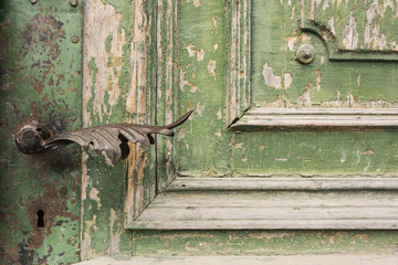 Old knob on vintage wooden door with cracked paint