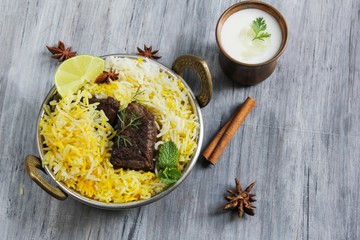 Beef Biryani with yogurt dip on wooden background, selective focus