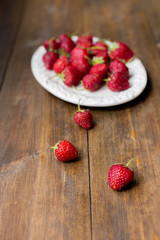 organic fresh sweet strawberries as a seasonal breakfast in the morning right from farmers market on dark wood table background decorated in rustic style
