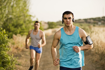 Runners friends in the road in sunny day