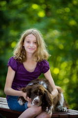 pretty teen girl sitting outdoors with her pet springer spaniel dog