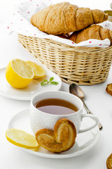 Cup of tea  with pretzels and croissants