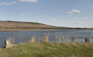 Old columns line a river in New England. 