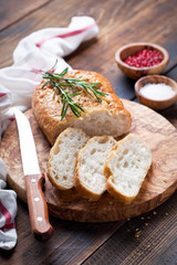 Ciabatta with rosemary on a wooden board, selective focus