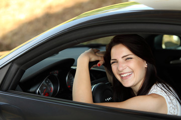 Piękna dziewczyna w sportowym samochodzie.