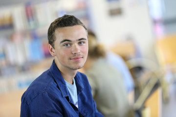 Student boy sitting on table in library room