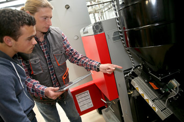 Young man in professional training measuring heat pump temperature