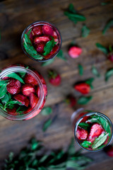 strawberry mint infused water decorated in rustic style on dark wood table background