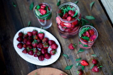 strawberry mint infused water decorated in rustic style on dark wood table background