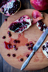 organic pomegranate open cut in half and full one on a wooden dark table background decorated in rustic style
