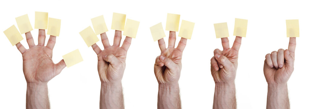 five hands holding post it on finger
