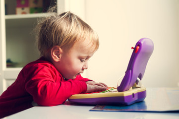 Cute little baby playing with computer, toned image