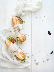 Sandwiches with beef, fresh vegetables and herbs over white wood © sonyakamoz