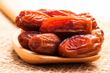 dried dates on wooden spoon cloth background