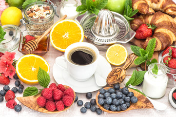 Fototapeta na wymiar Breakfast table setting with coffee, croissants, muesli, honey.