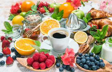 Coffee, croissants, granola, honey, fresh berries, fruits, flowe